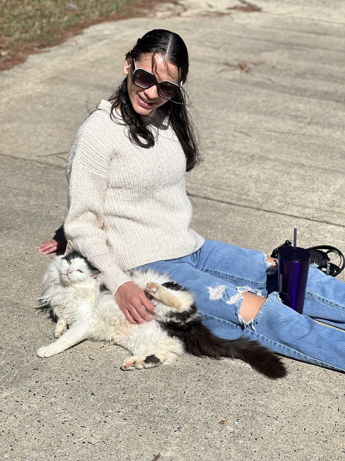 Cruella lying completely relaxed beside a founder while receiving affection